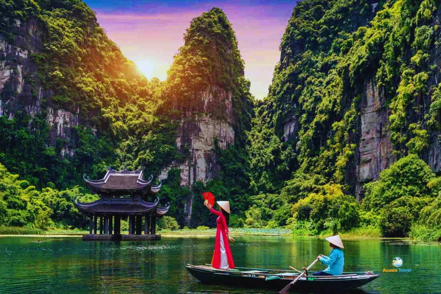 Boat on river amid limestone cliffs in Trang An Ninh Binh Vietnam – Auasia Travel